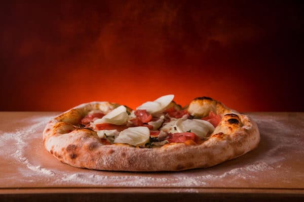 Homemade sourdough discard pizza crust topped with cheese and tomatoes.