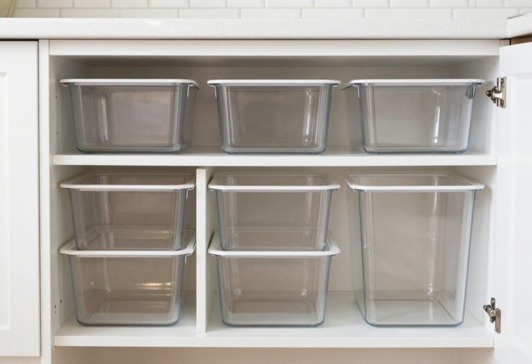 Organized pull-out pantry shelves with clear bins and labels in a bright kitchen