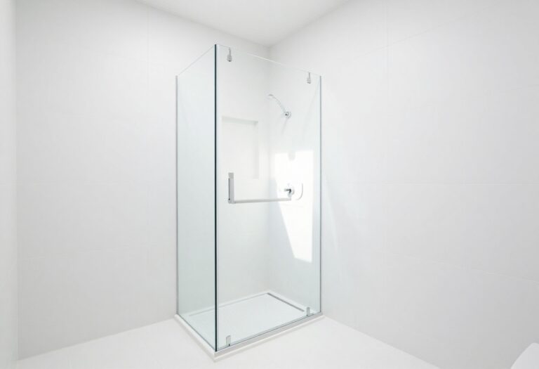 Modern walk-in tile shower with large white tiles and frameless glass