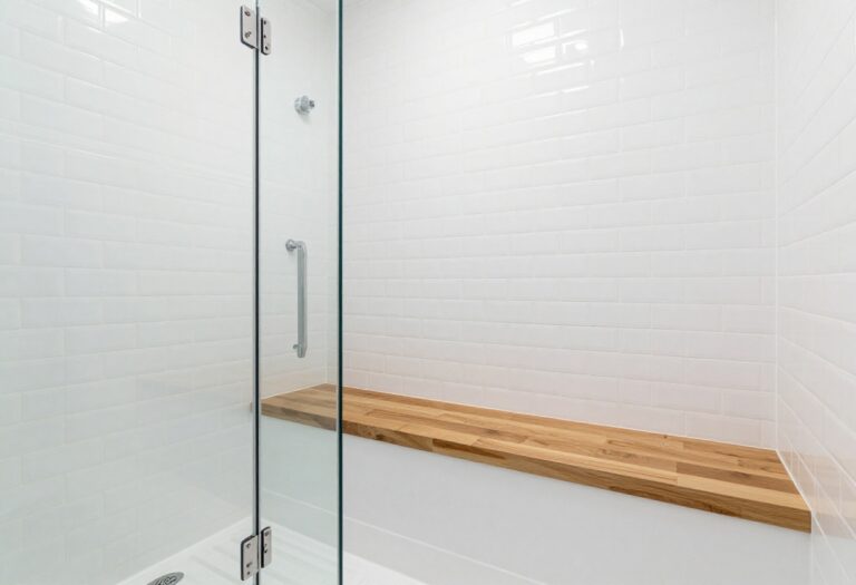 Modern tile shower with a teak wood seat and white subway tile