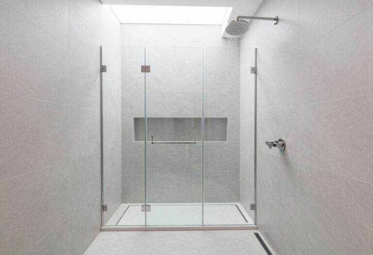 Modern walk-in shower with glass enclosure and skylight in a bright bathroom